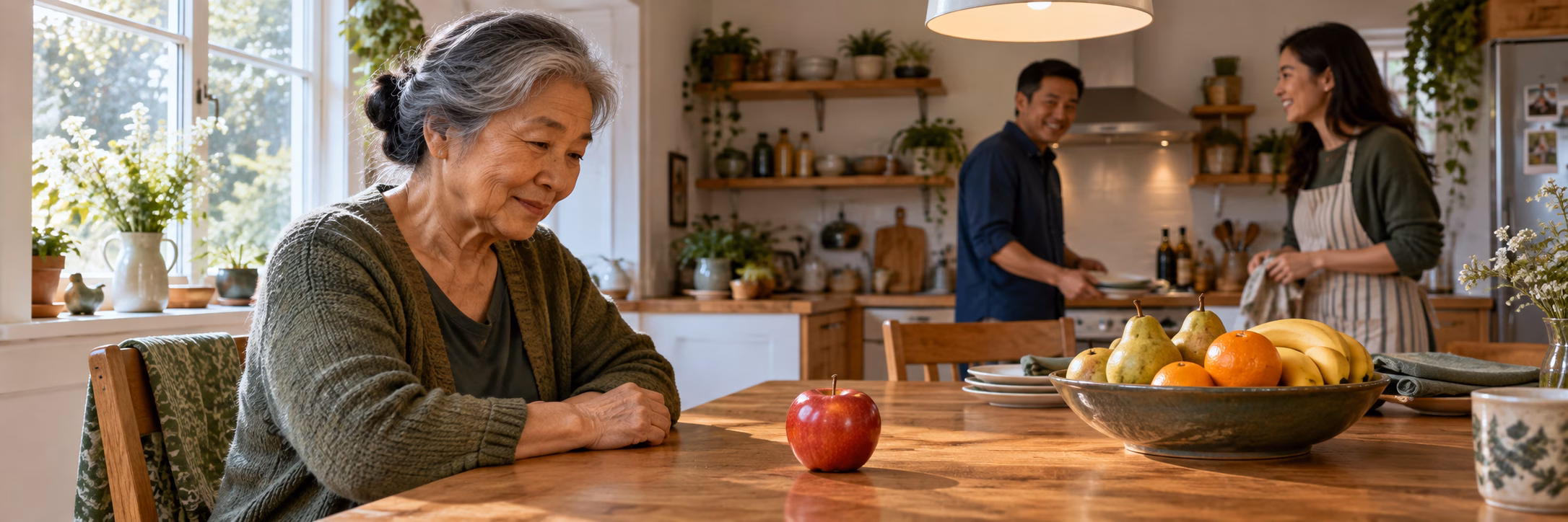 Una mujer observa una manzana en una cocina con otras frutas y personas
